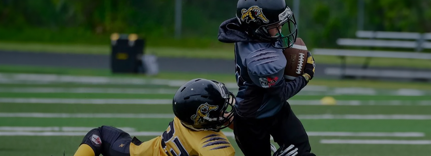 Youth football players on field wearing custom team jerseys
